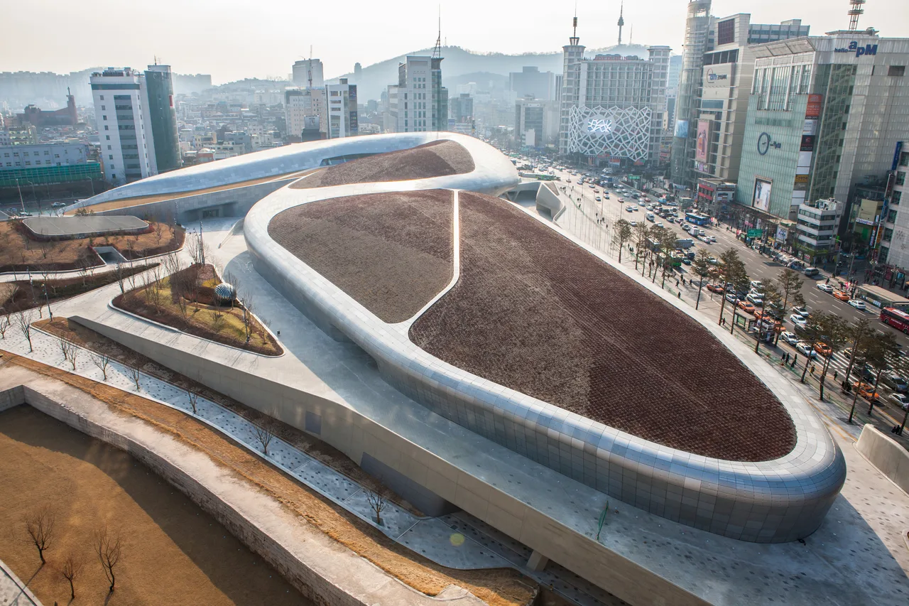 Crowds outside Dongdaemun Design Plaza lit up at night in Seoul